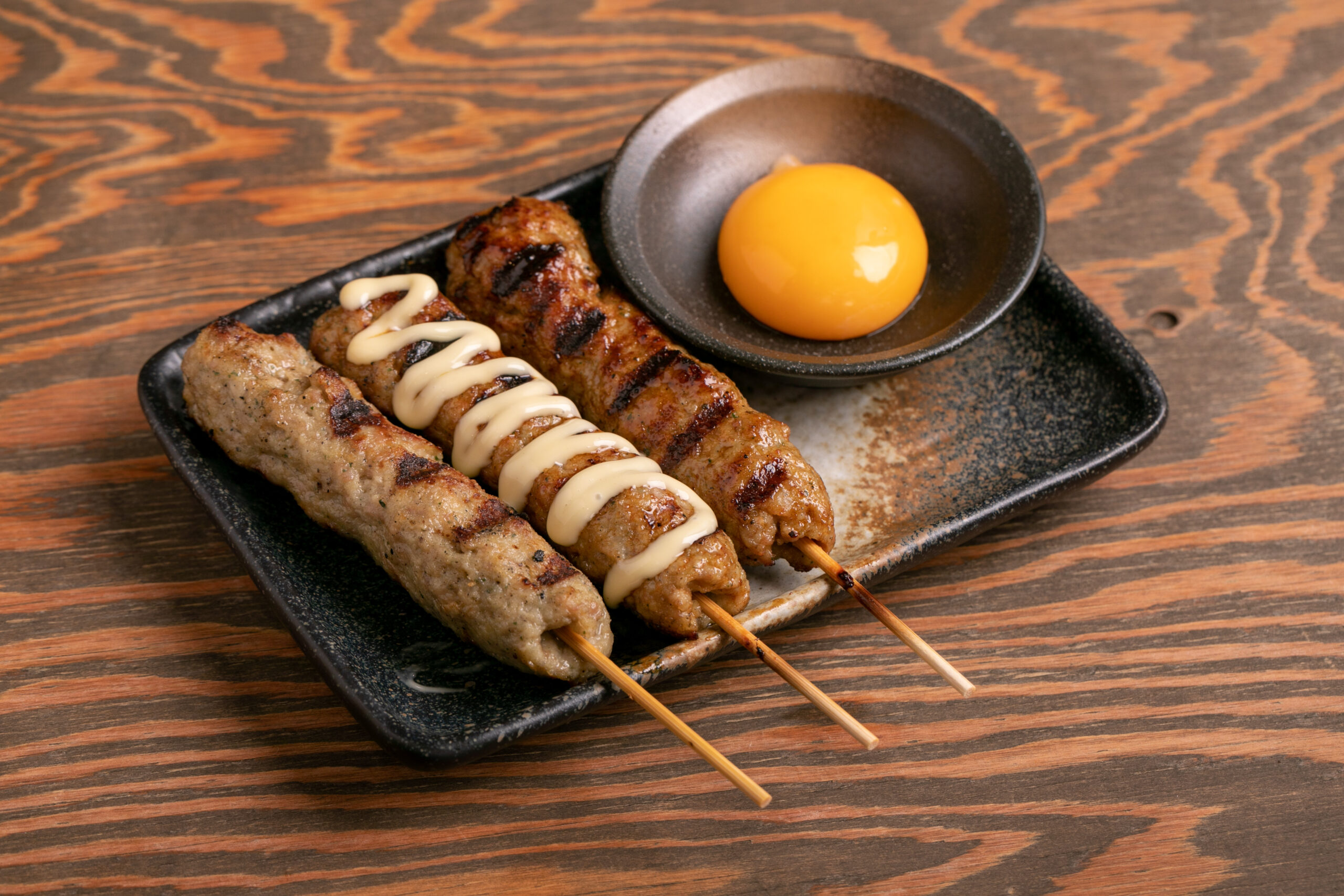 国産若鶏など11種類の材料を混ぜ合わせた、やわらかくてとろけるような食感の炭火焼き「生つくね」が人気