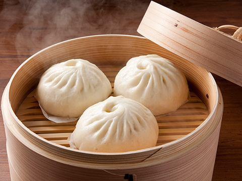 写真:ふっくらとした生地とジューシーな具材が魅力の豚まん