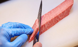 写真:丁寧に手切りされるこだわりの肉