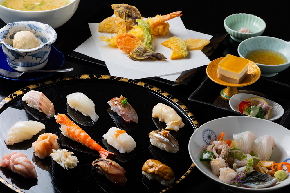 おまかせにぎり（蛇の目）は、にぎり12貫に加えて刺身や本日の一品、天ぷら、デザートまで付き、お店の魅力が凝縮されたコース