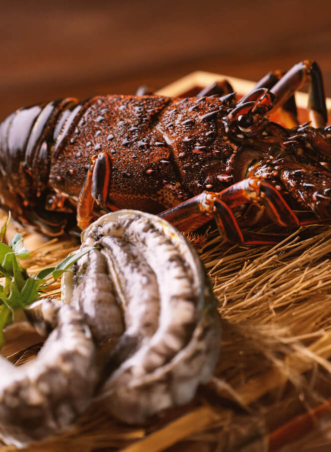 店内の生け簀から取り出される活きの良い伊勢海老と鮑