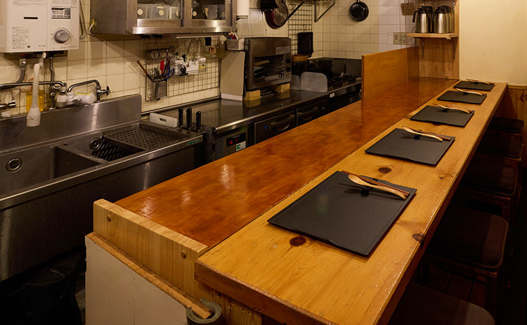 木のぬくもりに包まれた、店主の所作を間近に感じられるカウンター席