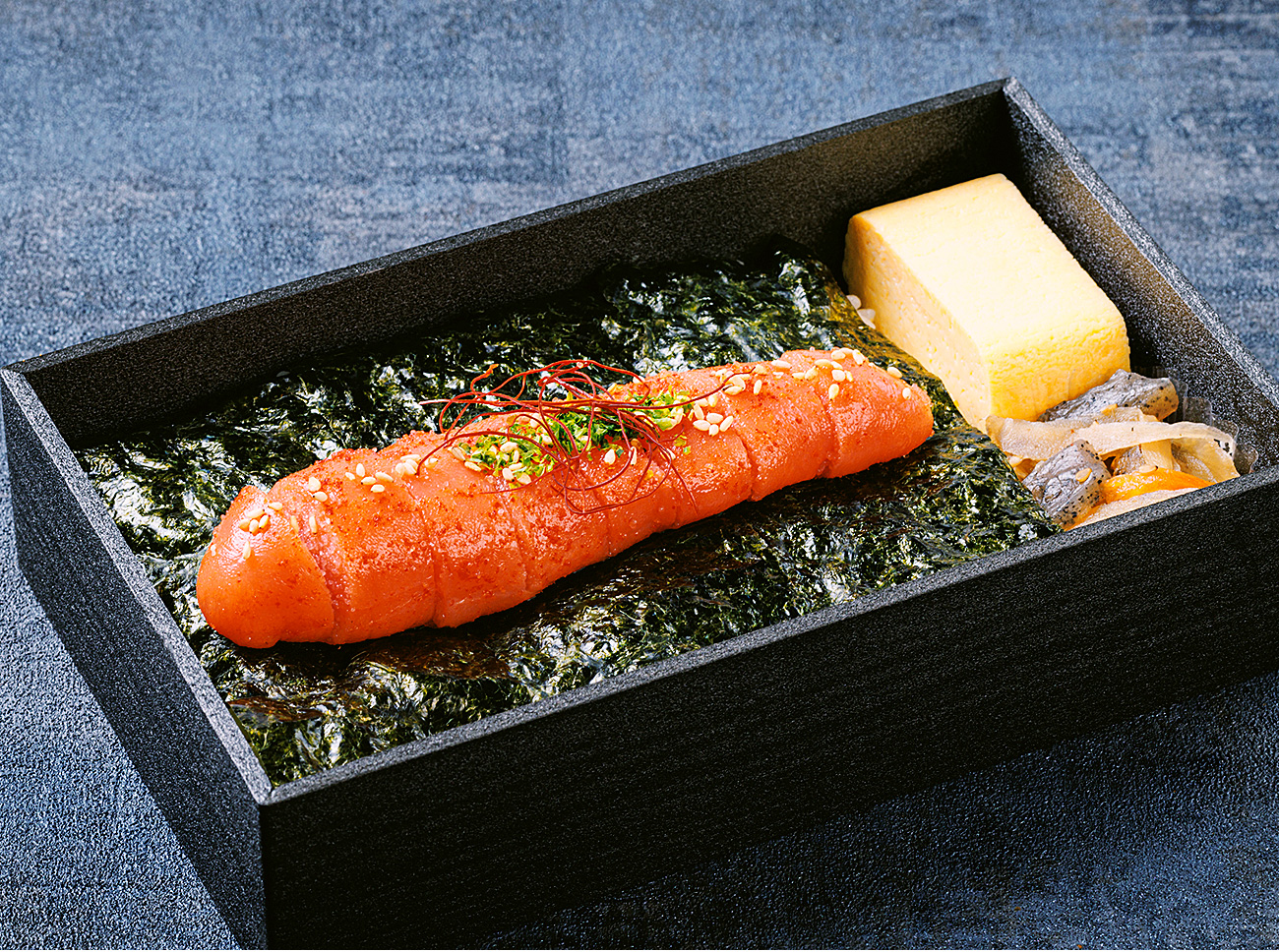 旅のお供にぴったりな美味しいごはんを楽しめるお弁当、明太子を丸ごと一本のせた「かねふく明太子1本弁当」も人気